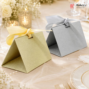 Two decorative boxes with ribbons on a table setting, featuring the Bakeyy brand.