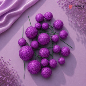 Purple glittery spherical flowers on a pink fabric background with 'Bakeyy' branding.