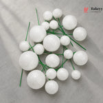 White spherical decorations on green stems with Bakeyy logo in the corner
