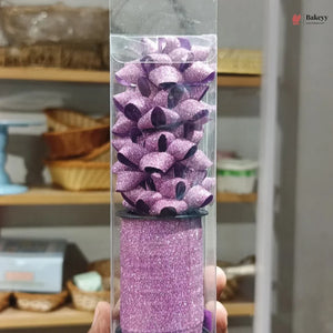 Purple glittery product in a clear tube held by a hand with a blurred background