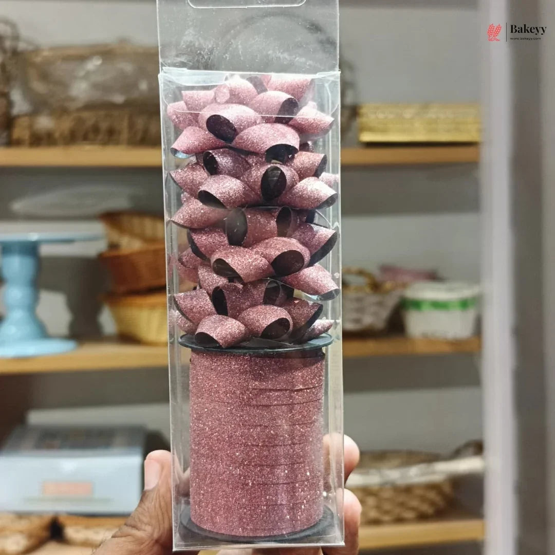 Packaged pink and black pasta held in front of a blurred store shelf.