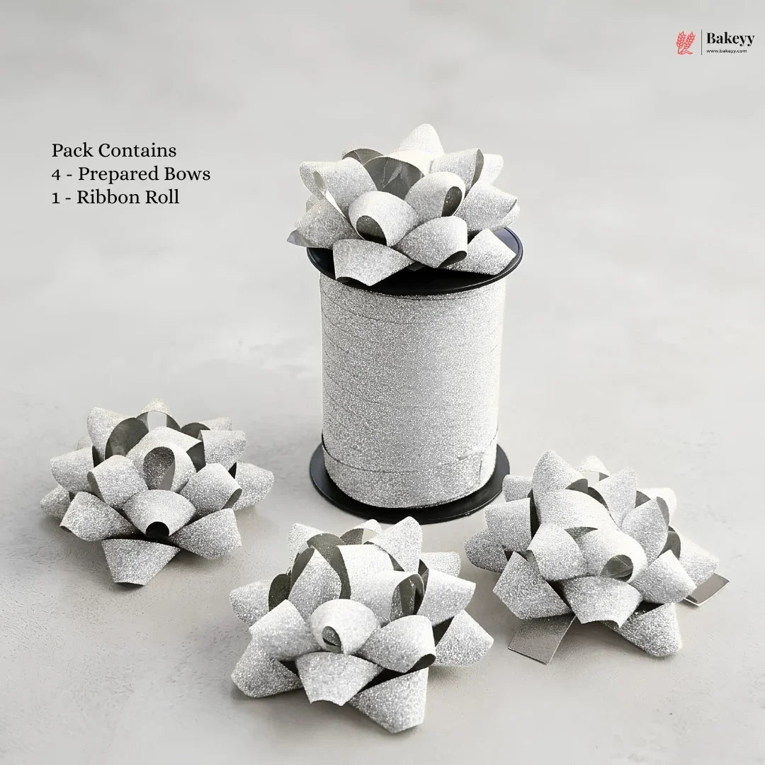 Bakey packaging with prepared bows and a ribbon roll on a light gray background