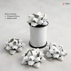 Bakey packaging with prepared bows and a ribbon roll on a light gray background