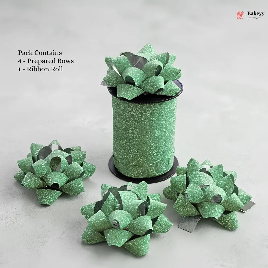 Green glittery bows and a roll of ribbon on a light gray background with 'Bakeyy' branding.