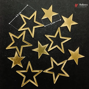 Nine gold-colored star-shaped metal beads or charms arranged on a black background, with white dimension lines and text indicating 4.5 cm by 3 cm measurements.