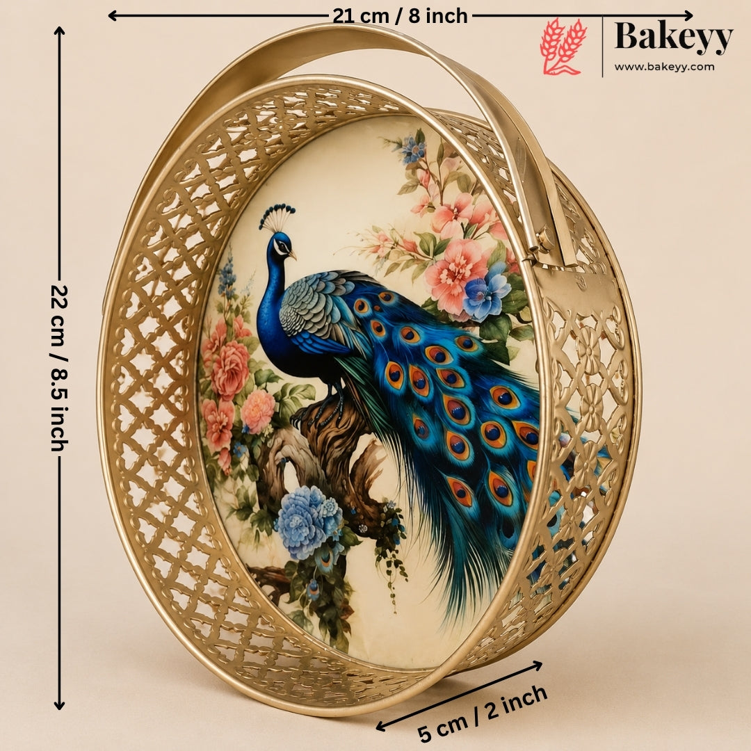 An oval decorative tray with a gold-tone metal frame and a central printed illustration of a peacock surrounded by flowers. Black measurement arrows and labels indicate the tray's dimensions: 22 cm height, 21 cm width, and 5 cm depth, on a beige background.
