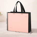 Pink tote bag with black handles and measurements on a light background