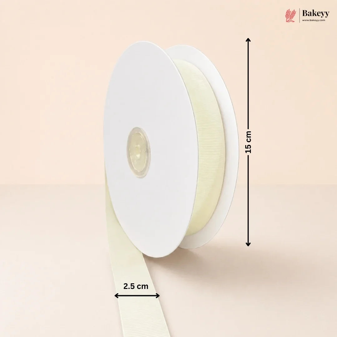 A spool of cream-colored ribbon on a light beige background, with dimension arrows and labels indicating a height of 15 cm and a width of 2.5 cm.