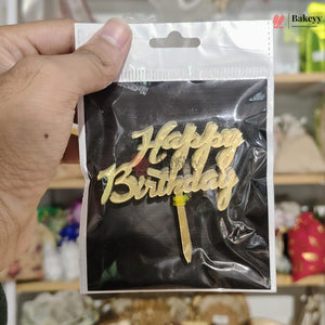Gold 'Happy Birthday' cake topper in clear packaging held by a hand.