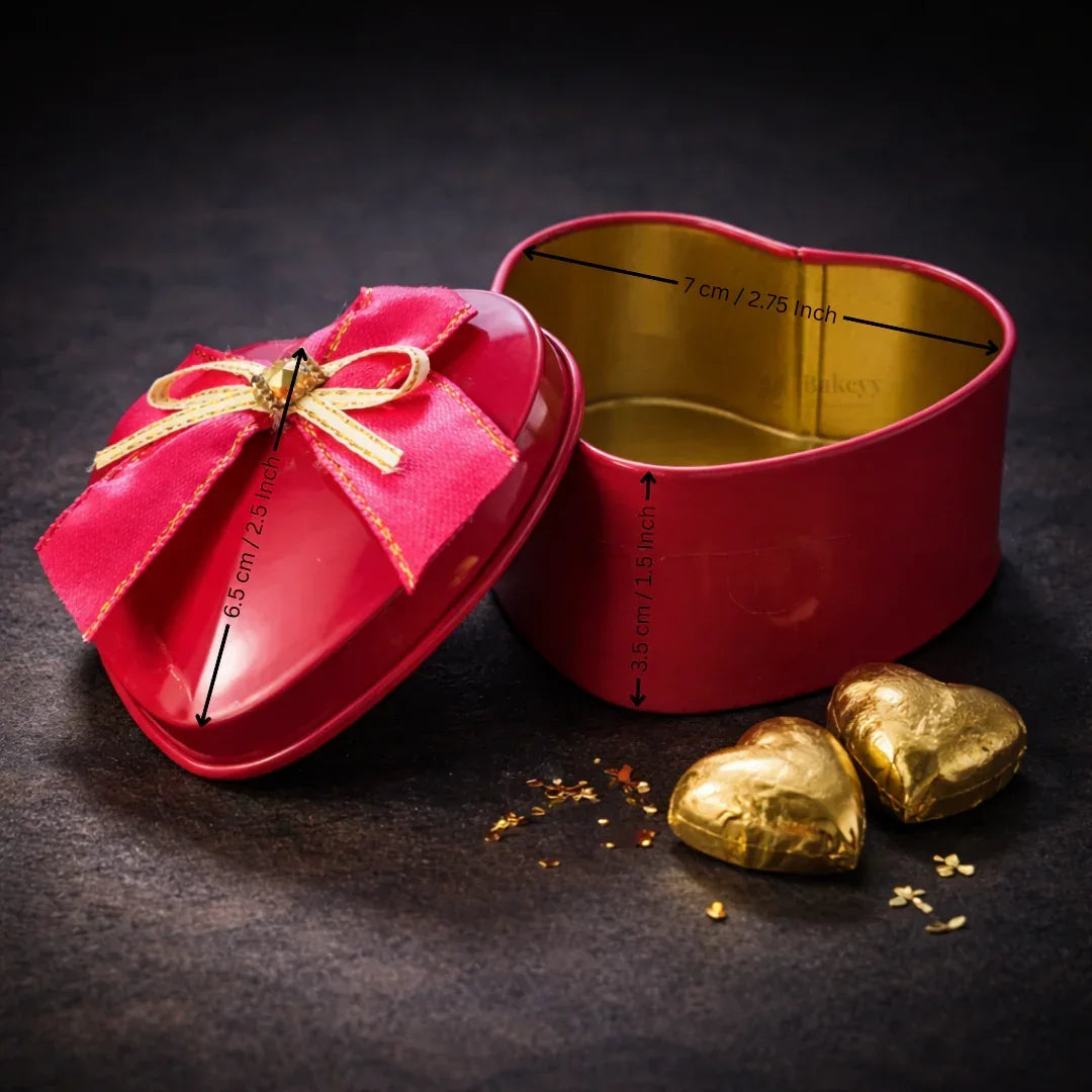 Red heart-shaped tin box with gold interior and bow, ideal for gift packaging from Bakeyy.com