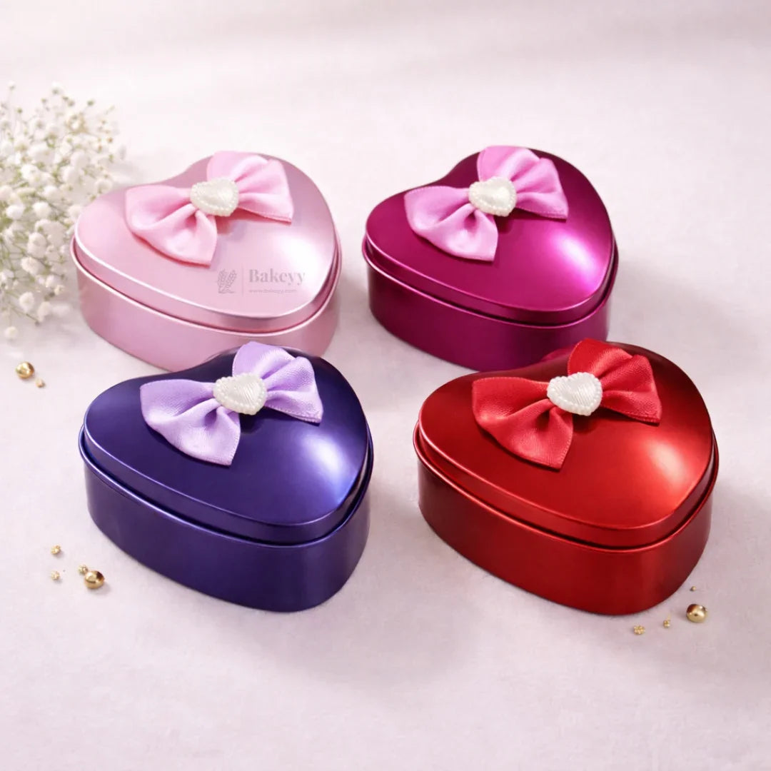 Colorful heart shaped tin gift boxes with satin bows from Bakeyy, ideal for packaging gifts.
