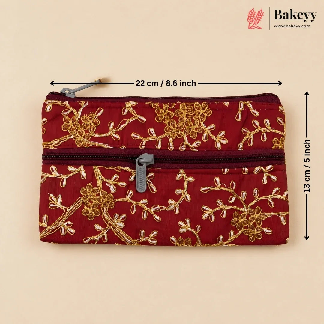 A red quilted zippered pouch with gold floral embroidery, shown on a beige background with dimension lines indicating 22 cm by 13 cm. The Bakeyy logo is visible in the top right corner.