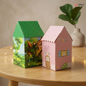 Two house-shaped boxes, one green and one pink, on a wooden table with a blurred background.