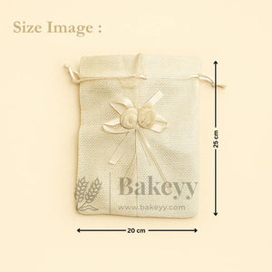 Cream jute potli bag with ribbon and floral accents, 20x25 cm, for gift packaging by Bakeyy