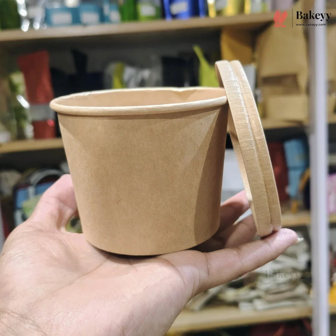 Brown paper cup with a lid held in a hand against a blurred store shelf background
