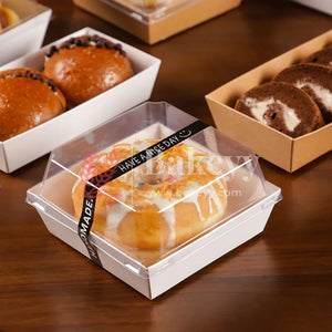 Baked goods in clear plastic containers on a wooden surface with 'Bakery' branding.