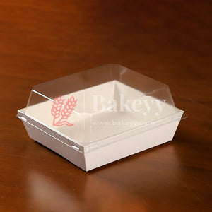 White disposable food container with clear lid on a wooden surface, featuring the 'Bakey' brand.