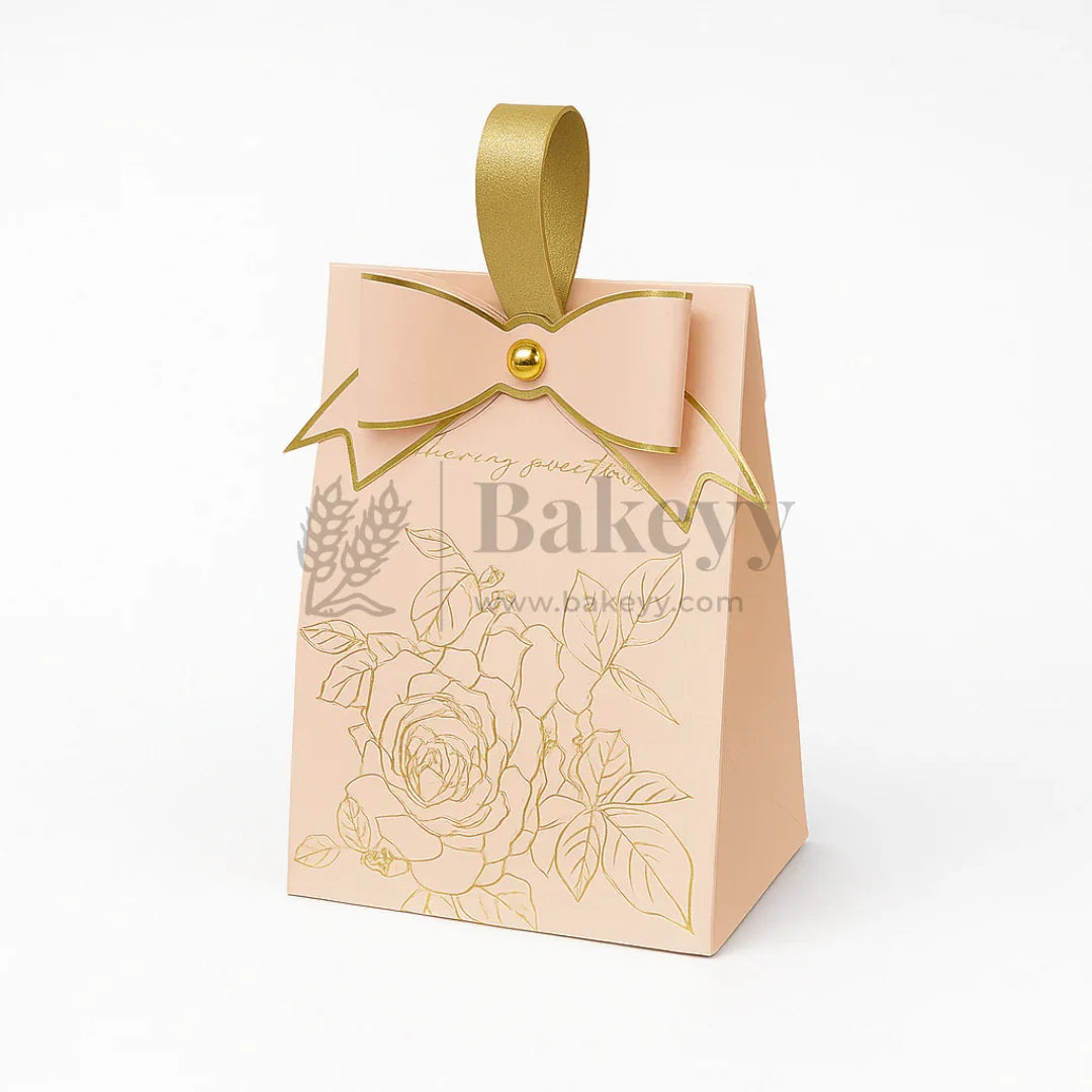Beige gift box with gold floral design and bow on a white background