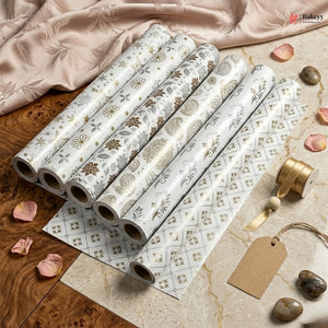 Rolls of decorative paper with floral patterns on a wooden surface.