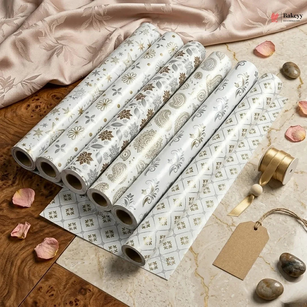 Rolls of decorative paper with floral patterns on a wooden surface.