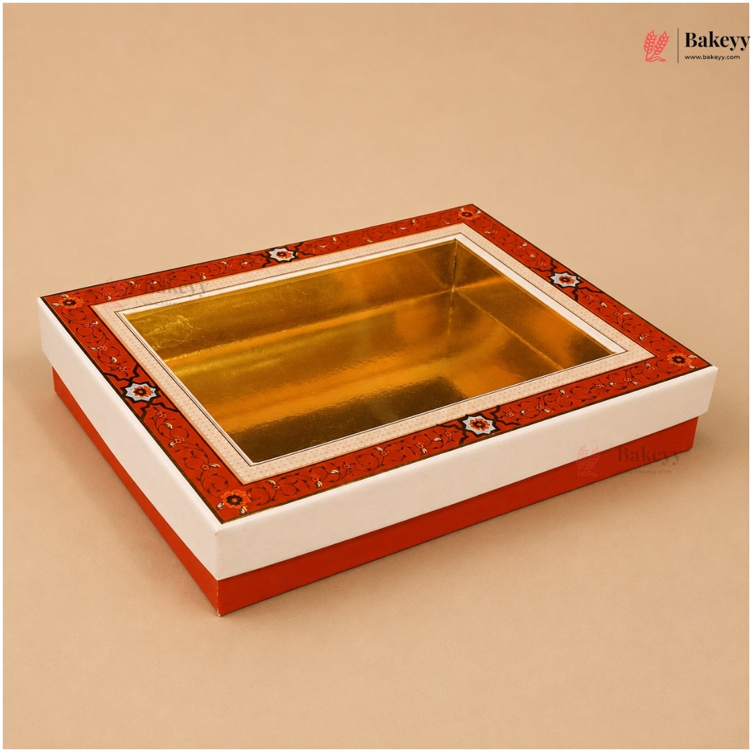 A rectangular gift box with a glossy gold interior and a red patterned border, shown on a plain beige background. A small Bakeyy watermark appears in the top right corner.
