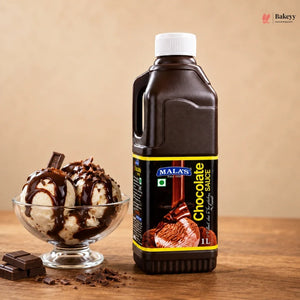 Bottle of Malas chocolate sauce with a bowl of ice cream topped with chocolate sauce on a wooden surface.