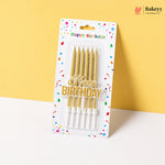 Pack of gold birthday candles with 'Happy Birthday' text on a colorful package against a yellow background.