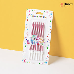 Pack of pink birthday candles with 'Happy Birthday' text on a colorful card against a yellow background