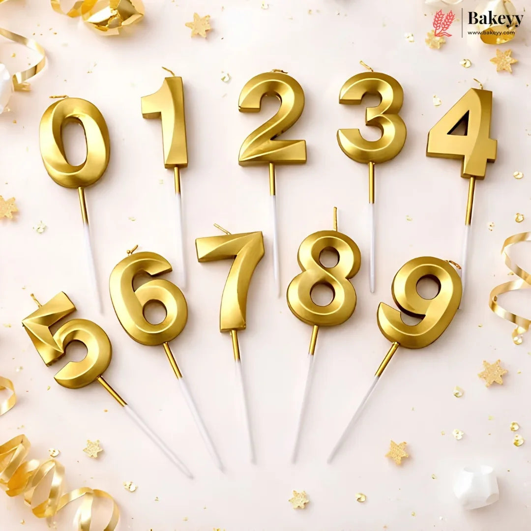 Set of ten gold number candles from 0 to 9 on white sticks, arranged on a light pink background with gold star and ribbon decorations. The Bakeey brand logo is visible in the top right corner.