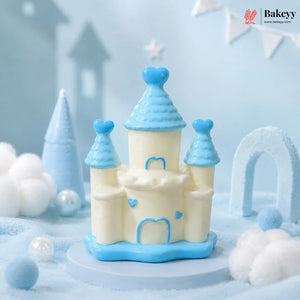 Decorative castle cake with blue and white design on a light blue background, featuring the Bakeyy brand.