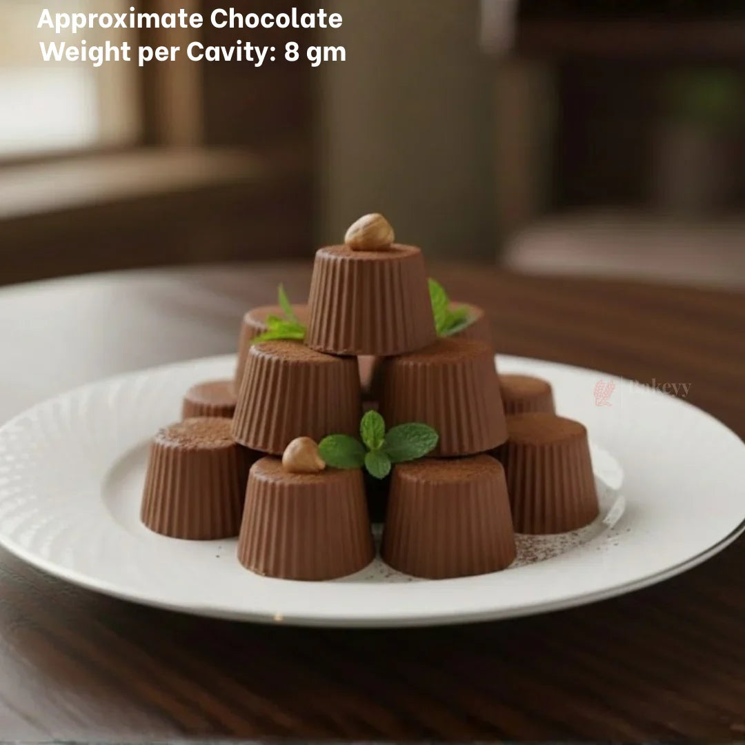 Stacked homemade chocolate cups on white plate, garnished with mint and nuts, made with Bakeyy chocolate mould.