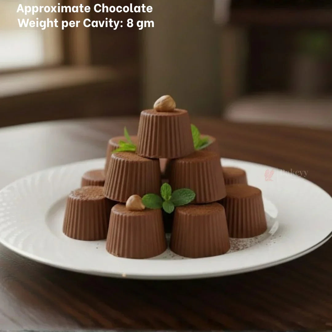 Stacked homemade chocolate cups on white plate, garnished with mint and nuts, made with Bakeyy chocolate mould.