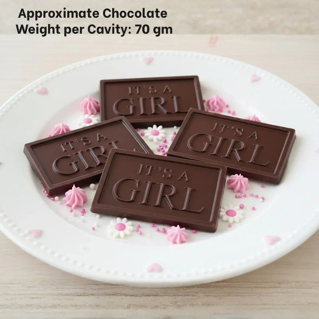 Chocolate bars with 'It's a Girl' text on a white plate, decorated with pink and white sprinkles; ideal for baby shower party favors, baking supplies from Bakeyy.com.