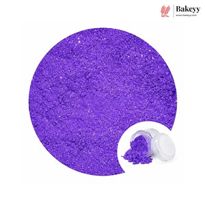 A circular close-up of bright purple glitter powder with a small inset showing an open clear jar and spilled powder, on a white background. The Bakeyy logo appears in the top right.