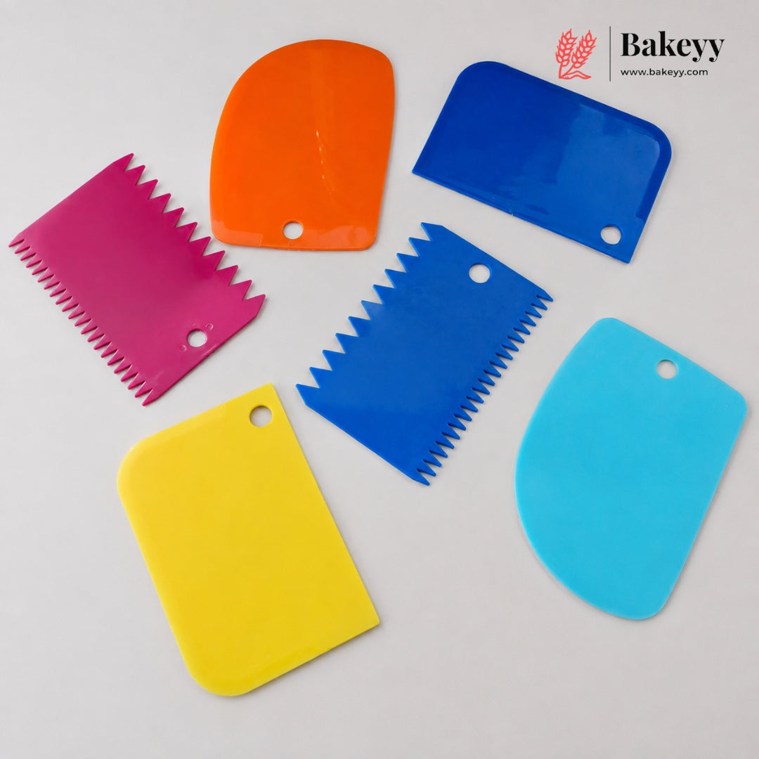 Six colorful plastic pastry scrapers in pink, orange, blue, yellow, and light blue, arranged on a light gray background with a Bakeyy logo in the top right corner.