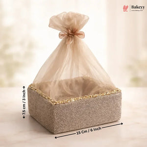 Square gift box with decorative ribbon and measurements on a light background
