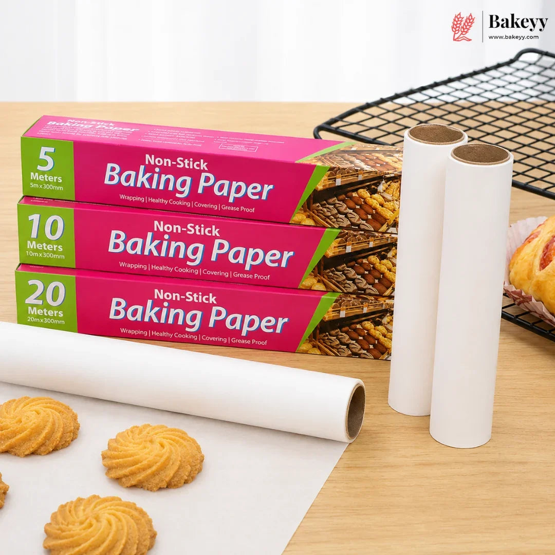 Three boxes of Bakey Non-Stick Baking Paper in 5, 10, and 20 meter sizes, alongside two white rolls of baking paper and several golden cookies on a light wood table.