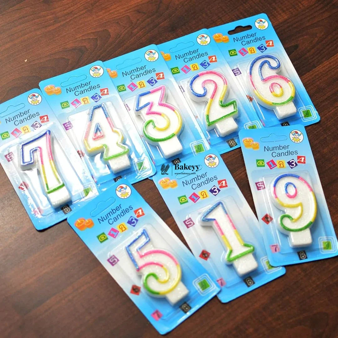 Rainbow number candles in colorful packaging for cakes, displayed on a wooden table, Bakeyy.com