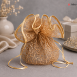 Gold lace bag with decorative ribbon on a gray surface