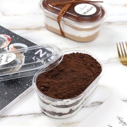 Two dessert containers with layered fillings on a marble surface