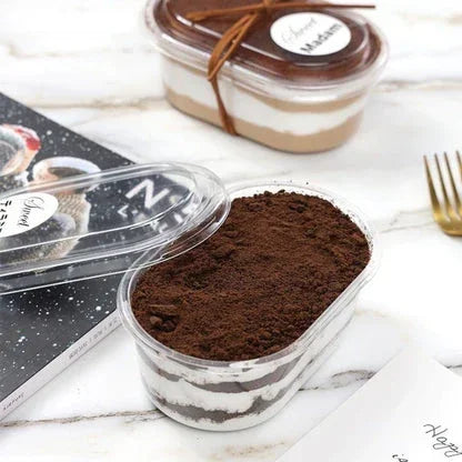 Two dessert containers with layered fillings on a marble surface