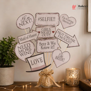 Decorative wedding centerpiece with speech bubble signs on a wooden table.