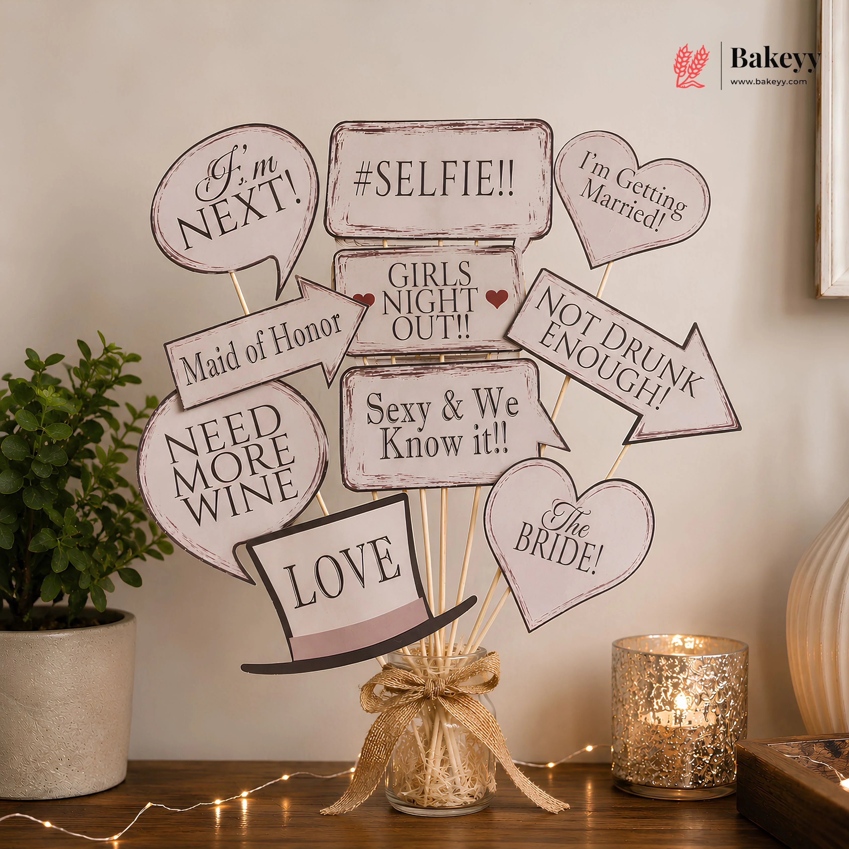 Decorative wedding centerpiece with speech bubble signs on a wooden table.