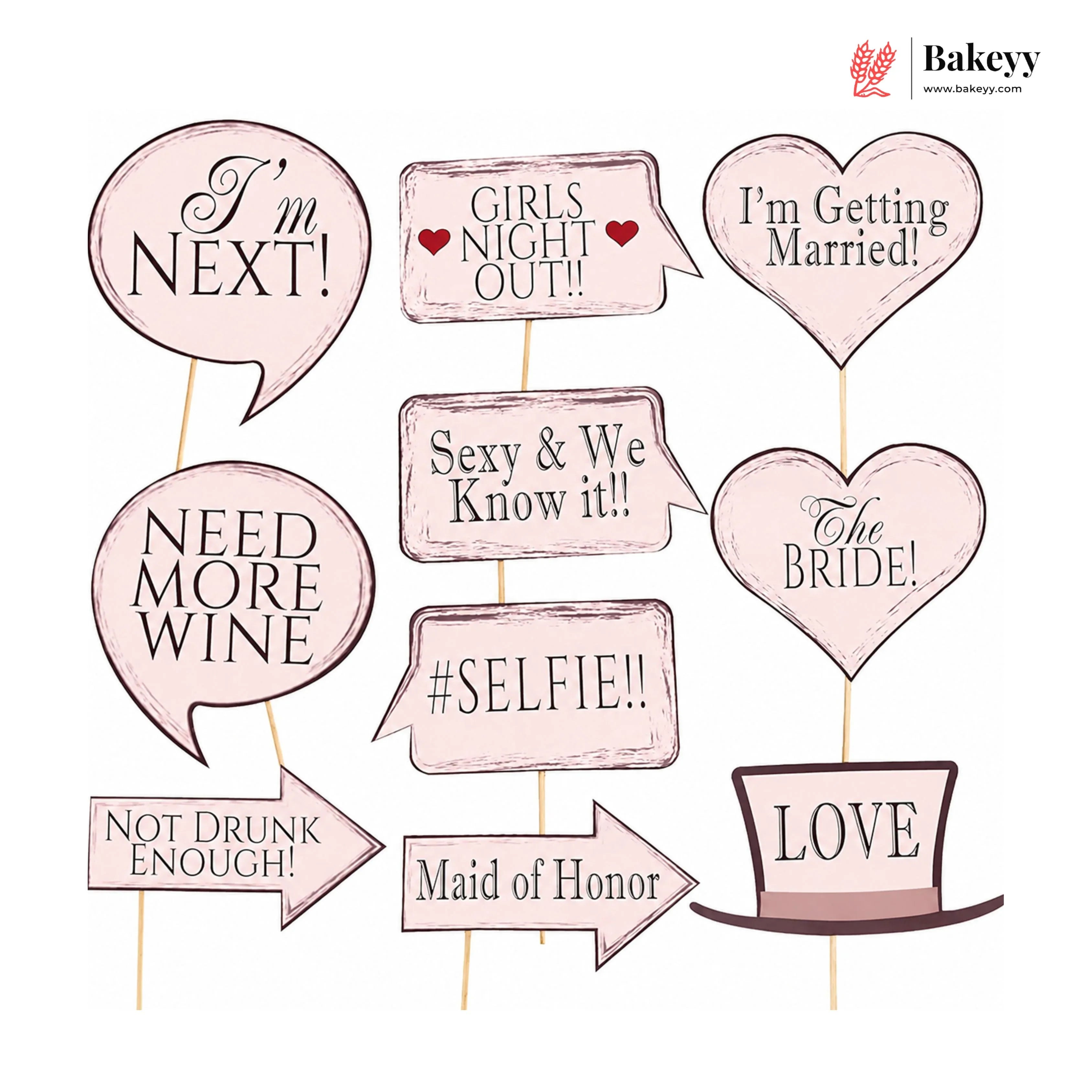 Set of pink photo booth props with wedding-themed sayings on a white background.