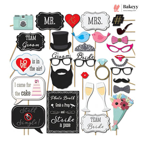 Collection of photo booth props with various items on sticks against a white background.