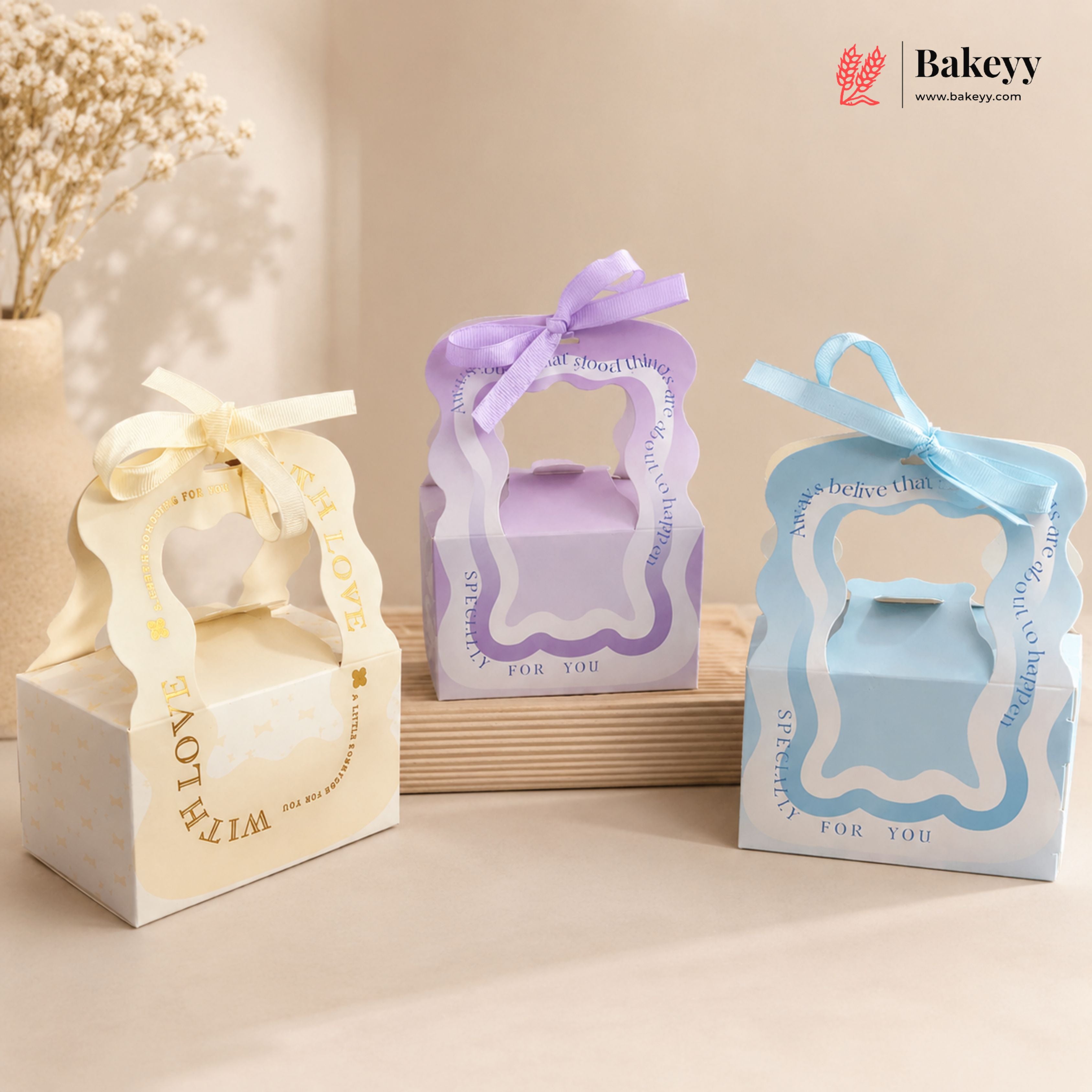 Three decorative gift boxes with ribbons on a neutral background, featuring the Bakeyy brand.