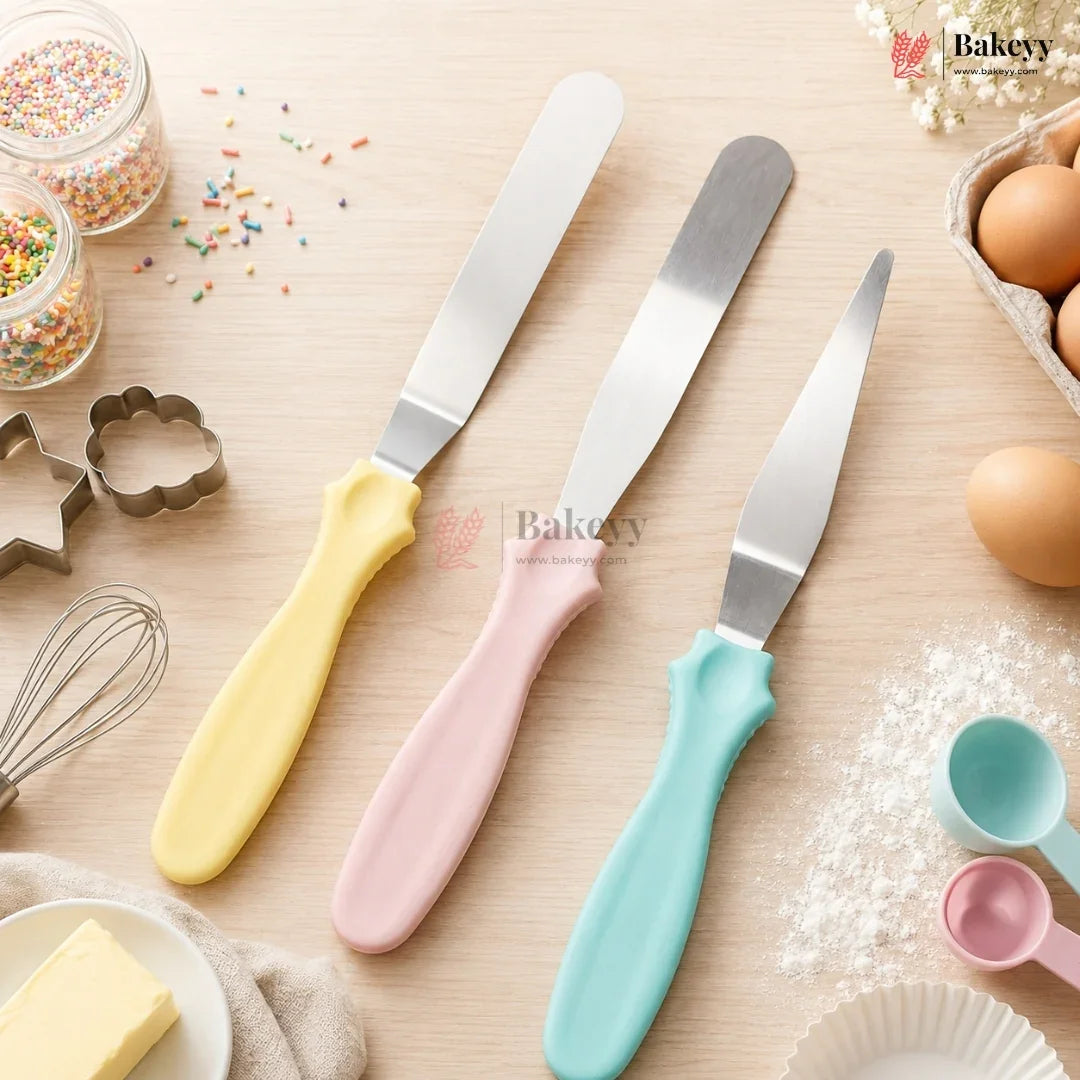 Three spatulas with pastel handles on a baking-themed background