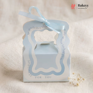 Gift box with blue ribbon and 'Bakeyy' branding on a beige background