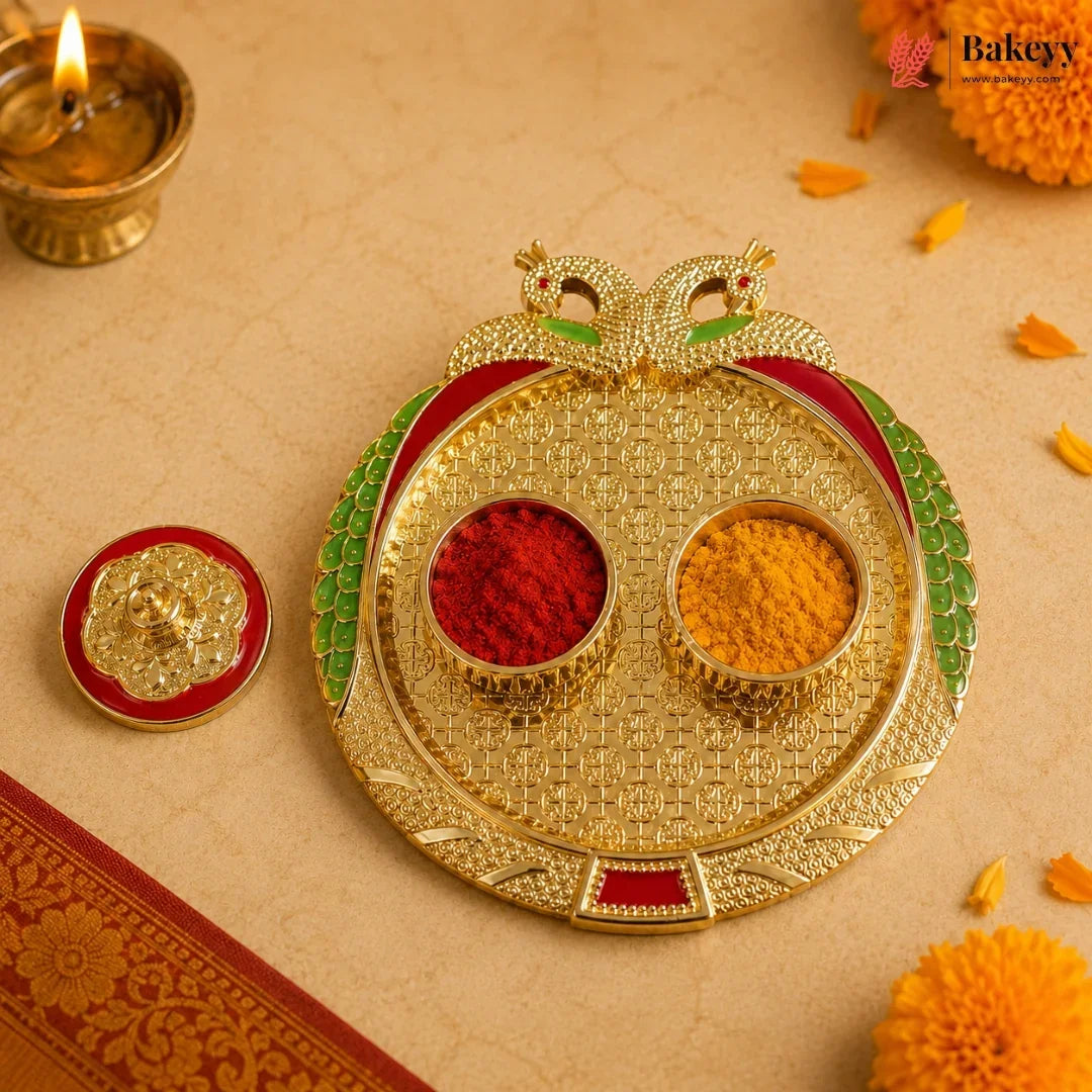 Decorative gold tray with red and yellow powders on a beige background with marigold flowers and a lit candle.