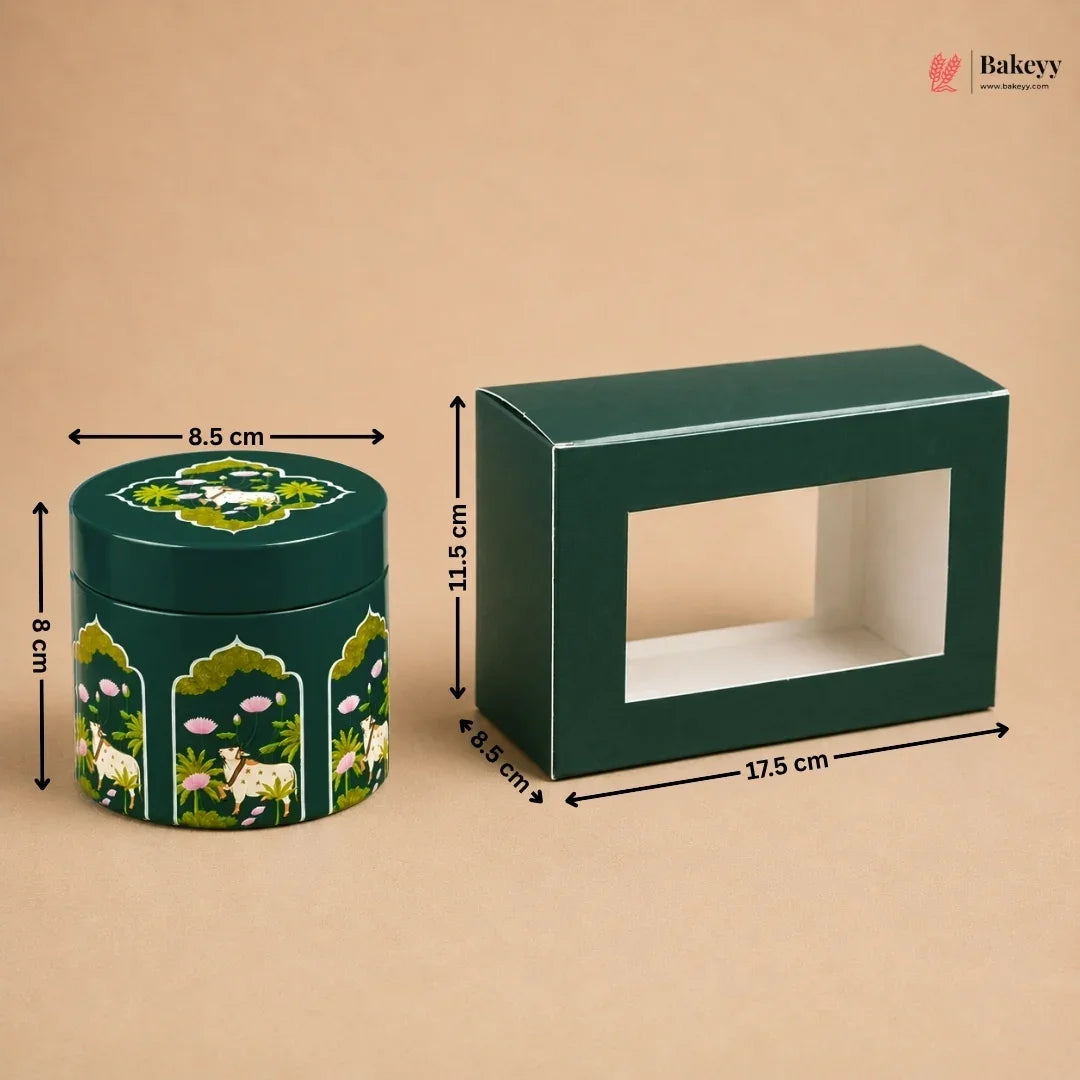 A dark green rectangular display box with a front window and a matching round decorative tin with animal and floral illustrations, shown on a beige background with dimension arrows and labels.
